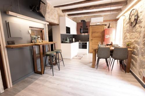 a kitchen and dining room with a table and chairs at Lo Raconet d'Arnes in Arnés