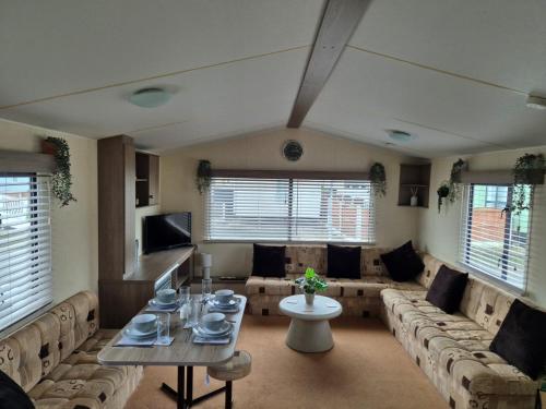 a large living room with couches and a table at A&J Caravan Hire Golden Gate Towyn in Kinmel Bay