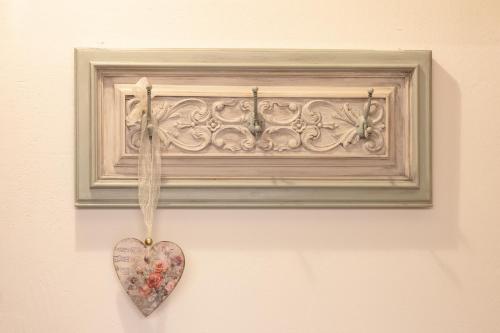 a heart ornament hanging on a wall with a picture at Lo Raconet d'Arnes in Arnés