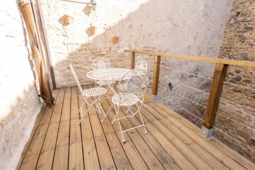 a patio with two chairs and a table on a deck at Lo Raconet d'Arnes in Arnés