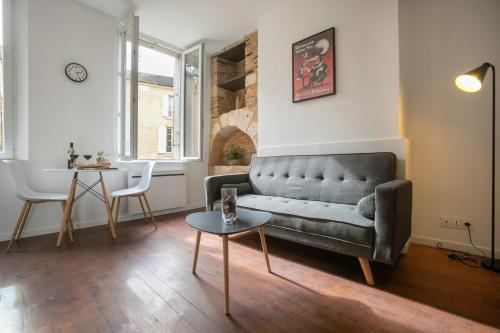 un salon avec un canapé et une table dans l'établissement Escapade de Charme T2 Centre Historique Bergerac, à Bergerac