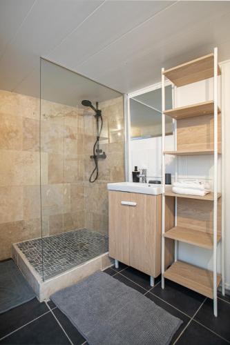 une salle de bain avec une douche avec un comptoir et un lavabo dans l'établissement Escapade de Charme T2 Centre Historique Bergerac, à Bergerac