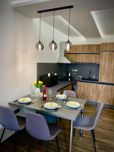 a dining room with a table and chairs and a kitchen at Pegazus Apartman in Keszthely