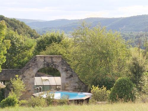 une baignoire dans un bâtiment en pierre avec une fenêtre dans l'établissement Quercynoise de Charme Piscine et vue sur Vallée du LOT, à Balaguier-dʼOlt