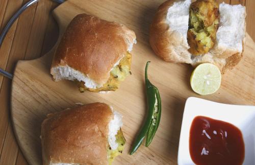 a cutting board with two halves of a sandwich and a lime at Capital O Seatree in Visakhapatnam