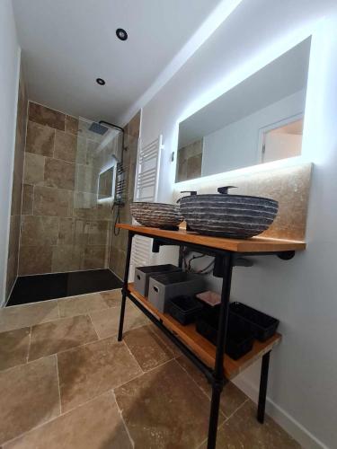 La salle de bains est pourvue d'une douche et d'une étagère avec des paniers. dans l'établissement Les Voiles Blanches, T3 neuf de 53 m2, à Saint-Jean-de-Monts