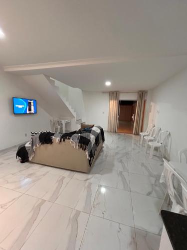 ein Wohnzimmer mit einem Sofa auf einem Marmorboden in der Unterkunft Temporada em Jauá in Camaçari