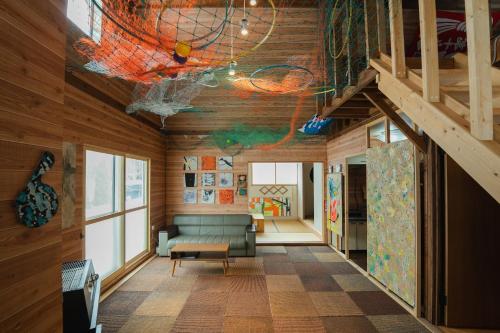 a living room with a couch and wooden walls at アルテミナガハク in Teshikaga