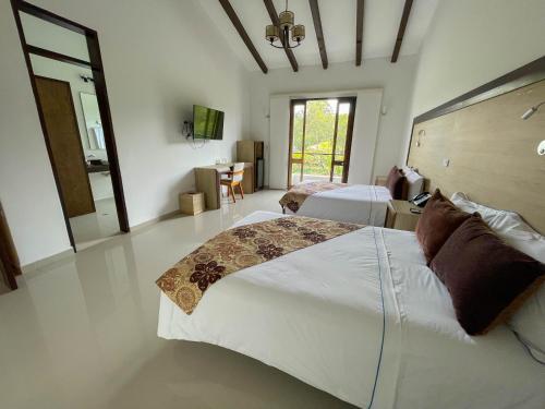 a large bedroom with a large bed and a table at Hotel La Magdalena Adult Only in Guatapé