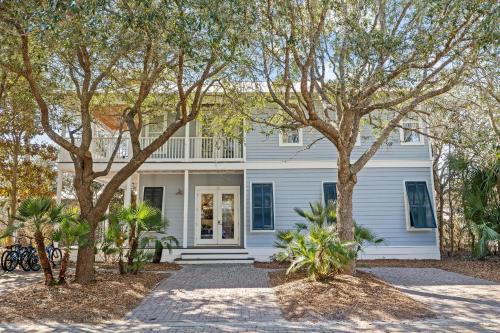 a white house with trees in front of it at Sand Pointe by 30A Escapes in Inlet Beach