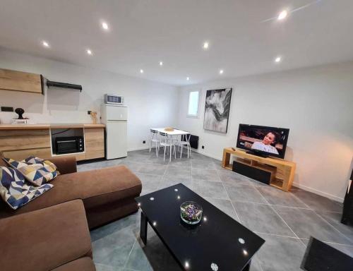 ein Wohnzimmer mit Sofa und Tisch in der Unterkunft Les Voiles Blanches, T3 neuf de 53 m2 in Saint-Jean-de-Monts