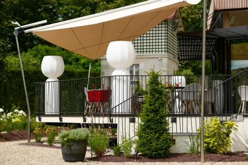 a patio with a table and chairs under an umbrella at Domaine Le Verbois in Chantilly