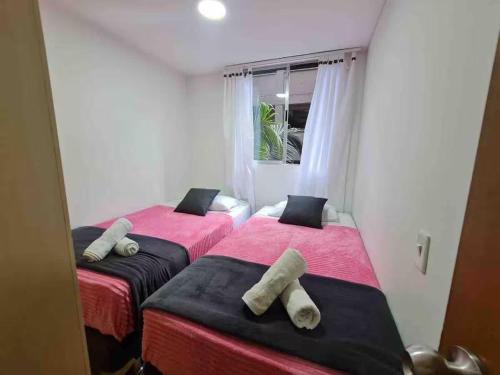two beds in a room with red and black sheets at Alojamiento Excepcional en zona Turística Vigo in Sabaneta