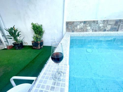 a glass of wine sitting next to a swimming pool at Casa de descanso con piscina Galileos in León