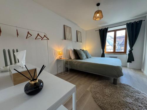 une chambre avec un lit et une table avec une lampe dans l'établissement Jolie T2, 55 m, centre ville soultz, à Soultz-Haut-Rhin