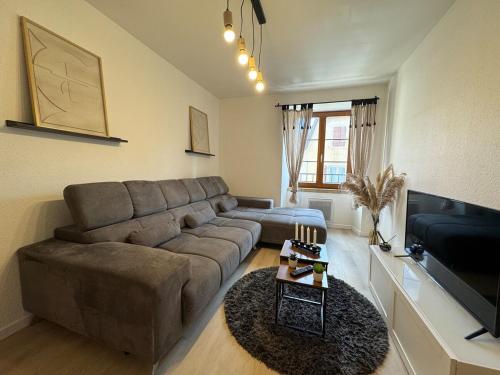 a living room with a couch and a flat screen tv at Jolie T2, 55 m, centre ville soultz in Soultz-Haut-Rhin