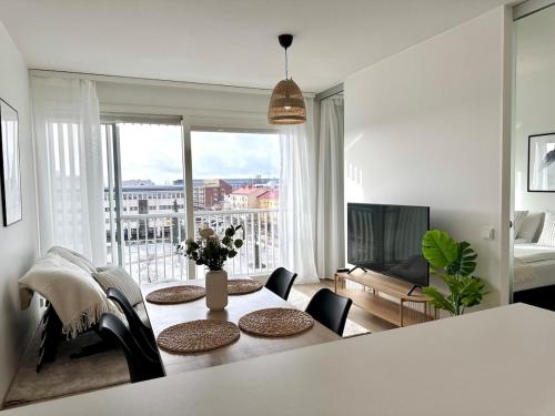 a living room with a table and chairs and a television at Luxury Apartment With The Best Location In Oulu in Oulu