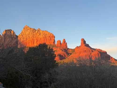 a view of the red rocks at sunset at Sedona Uptown Gem!Large yard w grass and shade trees! Views!! NEW! BARREL SAUNA!!! Close to trails, walk to Uptown Sedona, restaurants and shopping in Sedona