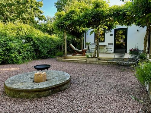 a garden with a table and a bench and a house at Wisteria Österlen in Simrishamn