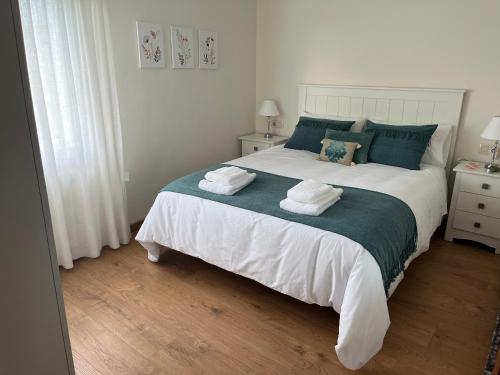a bedroom with a large bed with towels on it at O Refuxio de Tebra in Tebra