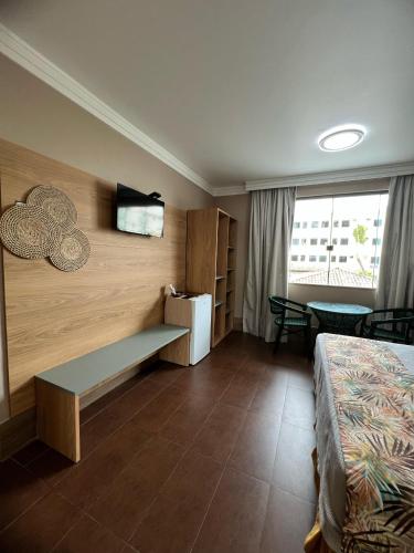 a hotel room with a bed and a tv on a wall at Pousada Praia Bela in Ilhéus