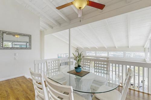a dining room with a glass table and white chairs at Hawaii Kai Dream in Honolulu