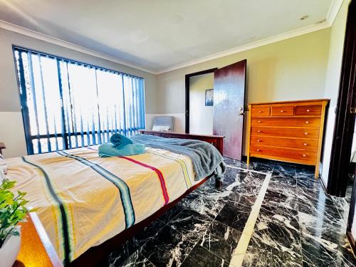 a bedroom with a bed and a dresser and window at Affordable Long-Term Stay ENS Master Bedroom in Perth Fremantle University Hospital in Perth