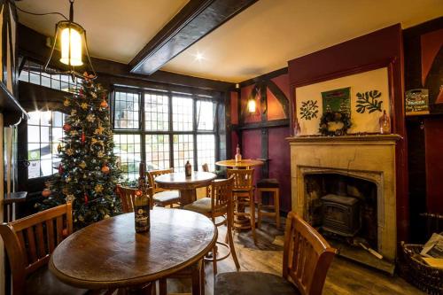 a living room with a christmas tree and tables at The Cardinals Hat in Worcester