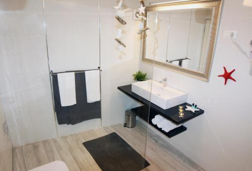 een badkamer met een wastafel en een spiegel bij Apartments Stefani in Fažana