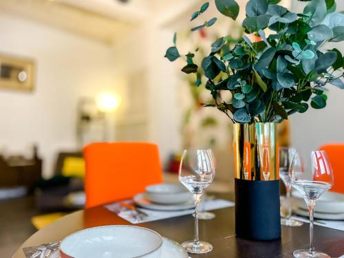 une table avec des verres et un vase avec une plante dans l'établissement RétroMirabeau 