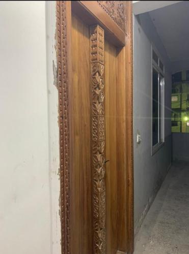 a wooden door with a mirror on a wall at Al-mendhiry Apartment in Zanzibar City