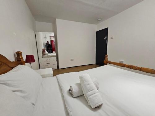a bedroom with two towels on a white bed at Rooms Near Canary wharf in London