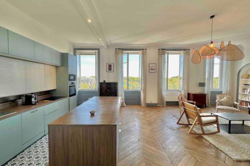 une cuisine et un salon avec une table et des chaises dans l'établissement Appartement de 160m2 proche centre Lyon, à Caluire-et-Cuire