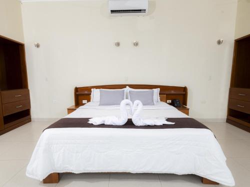 a bedroom with a bed with white shoes on it at Hotel San Marino Tarapoto in Tarapoto