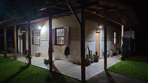 a house at night with the lights on at Casa Rústica na Lagoa-15 min do praia comWi-Fi quartos 2 possui cama de casal e 3 solteiro ideal para 5 pessoas in Osório