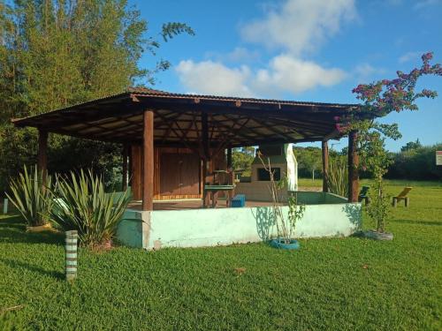 a gazebo in a yard with a green field at Casa Rústica na Lagoa-15 min do praia comWi-Fi quartos 2 possui cama de casal e 3 solteiro ideal para 5 pessoas in Osório