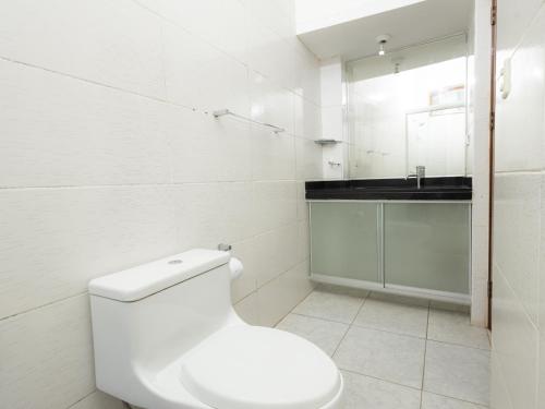 a white bathroom with a toilet and a sink at Hotel San Marino Tarapoto in Tarapoto
