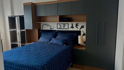 a bedroom with a bed with a blue comforter at Condomínio próximo a ponte Hercílio Luz in Florianópolis