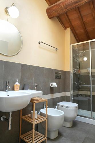 a bathroom with a sink and a toilet and a mirror at Honey Rooms Ferrara in Ferrara