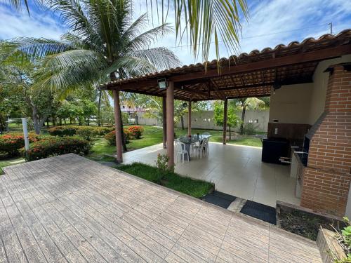 a patio with a pavilion with a table and chairs at Chácara Lara Bela in Praia do Saco