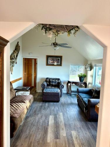 a living room with couches and a ceiling at Paradise Suites The Wolf Den in Homer