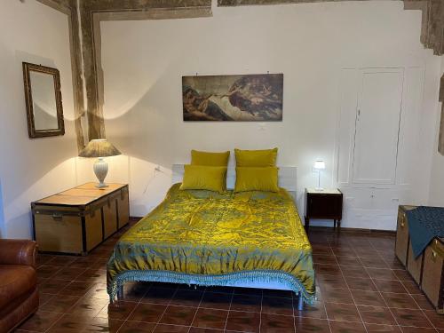 a bedroom with a bed with a yellow comforter at Il Palazzo del Borgo - Affittacamere in Todi
