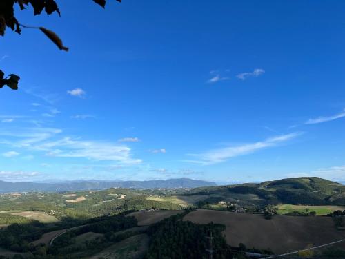a view of a valley with hills and a blue sky at Il Palazzo del Borgo - Affittacamere in Todi