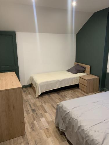 a room with two beds and two tables in it at Logement au calme, à proximité de tous in Damparis