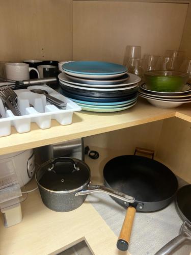 a kitchen with plates and pans on a shelf at Moonlight Stay Whitehorse Downtown in Whitehorse