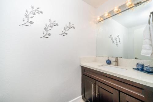 a bathroom with a sink and a mirror at Luxury Oceanfront Condo with Private Beach Access in Oceanside