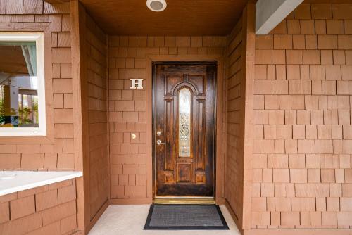 a brown door in a brown brick wall at Luxury Oceanfront Condo with Private Beach Access in Oceanside