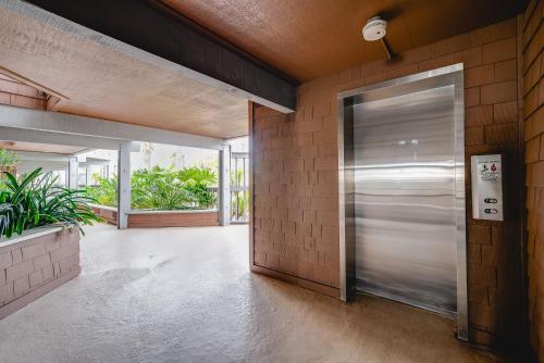 a metal elevator door in a building with plants at Luxury Oceanfront Condo with Private Beach Access in Oceanside