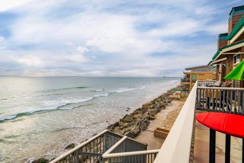 a view of the beach from the balcony of a resort at Luxury Oceanfront Condo with Private Beach Access in Oceanside