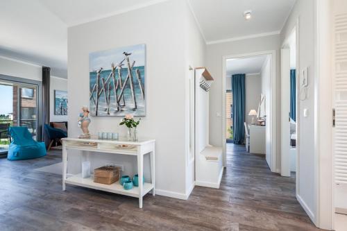 - un salon avec des murs blancs et une table blanche dans l'établissement Ostsee - Appartement Nr 80 "MeerSinn" im Strand Resort, à Heiligenhafen